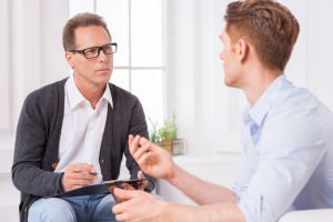 Cross Addiction Therapist talking treatment options with recovery patient