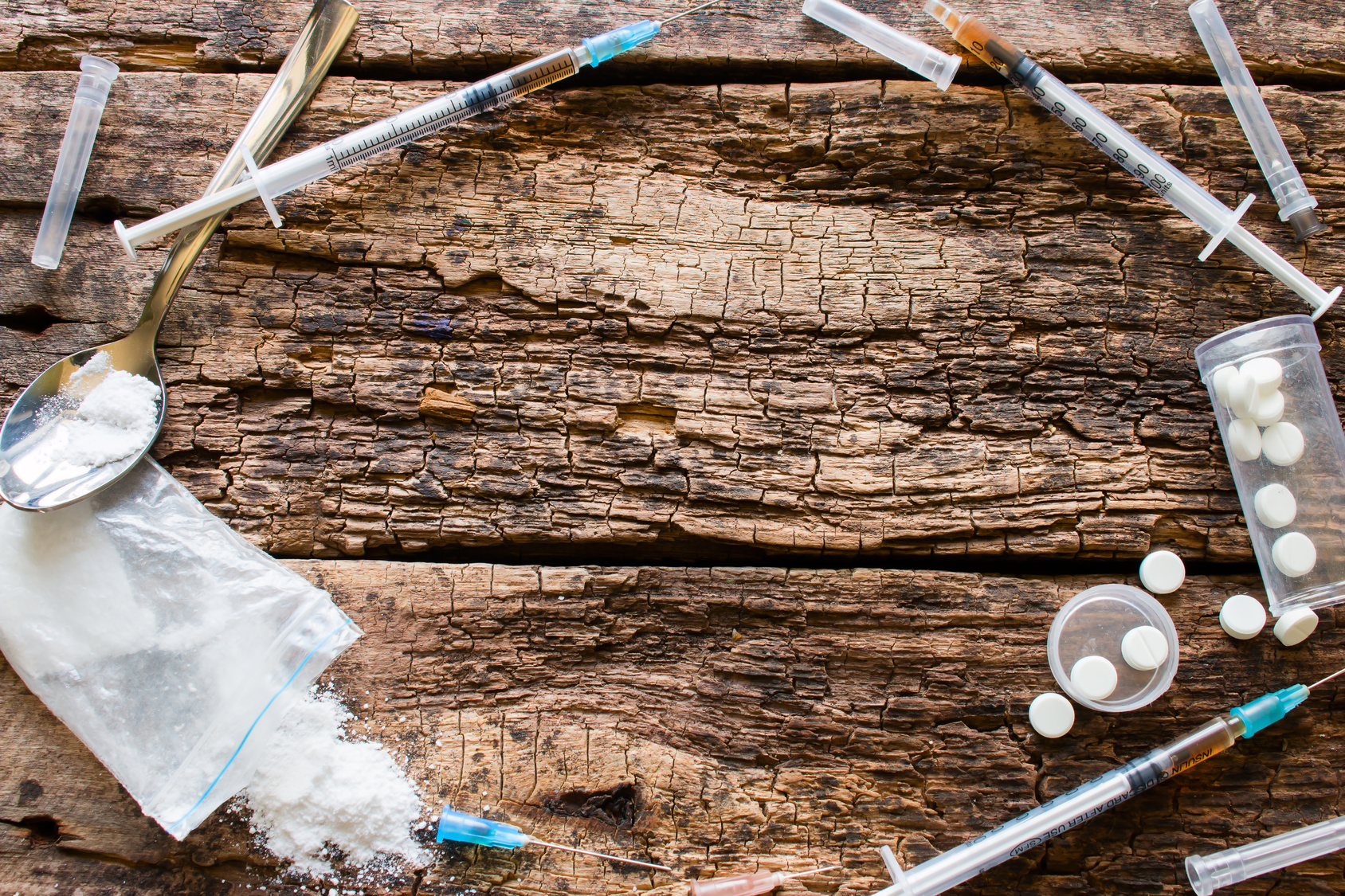 Drug Frame Drugs create a circle on a table made of wooden planks.