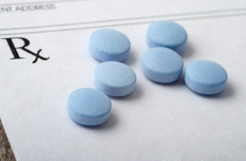 Six blue opioid pills on paper.